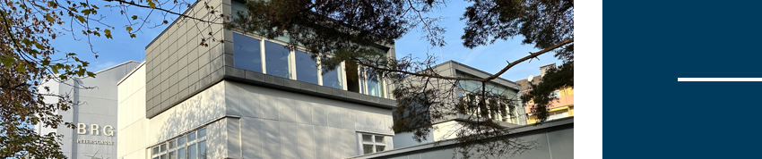 Außenansicht des Schulgebäudes hinter Bäumen