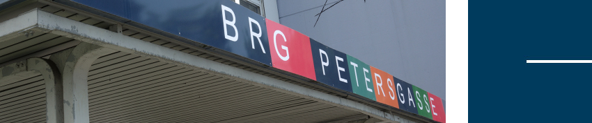 Bunter Schriftzug BRG Petersgasse über einem Vordach des Schulgebäudes