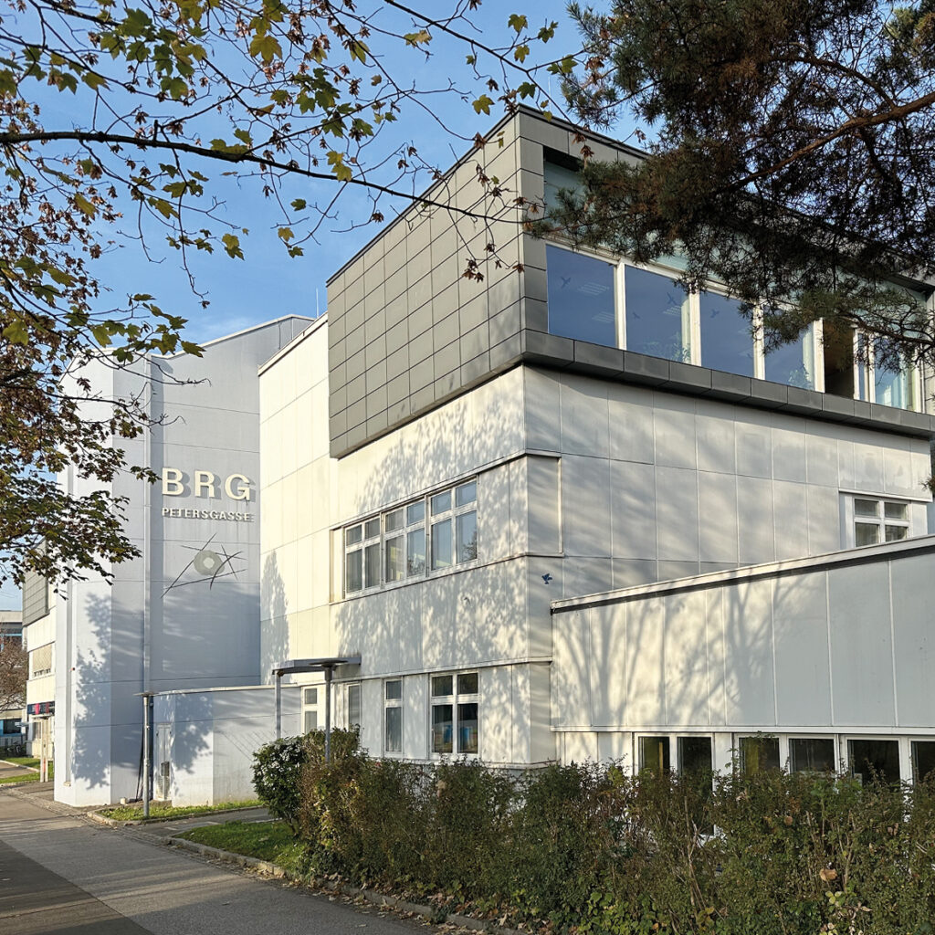Außenansicht des Schulgebäudes mit dem Schriftzug BRG, davor Bäume