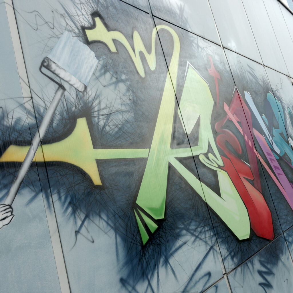 Großes Graffiti mit Pinselmotiv an einer Außenwand der Schule
