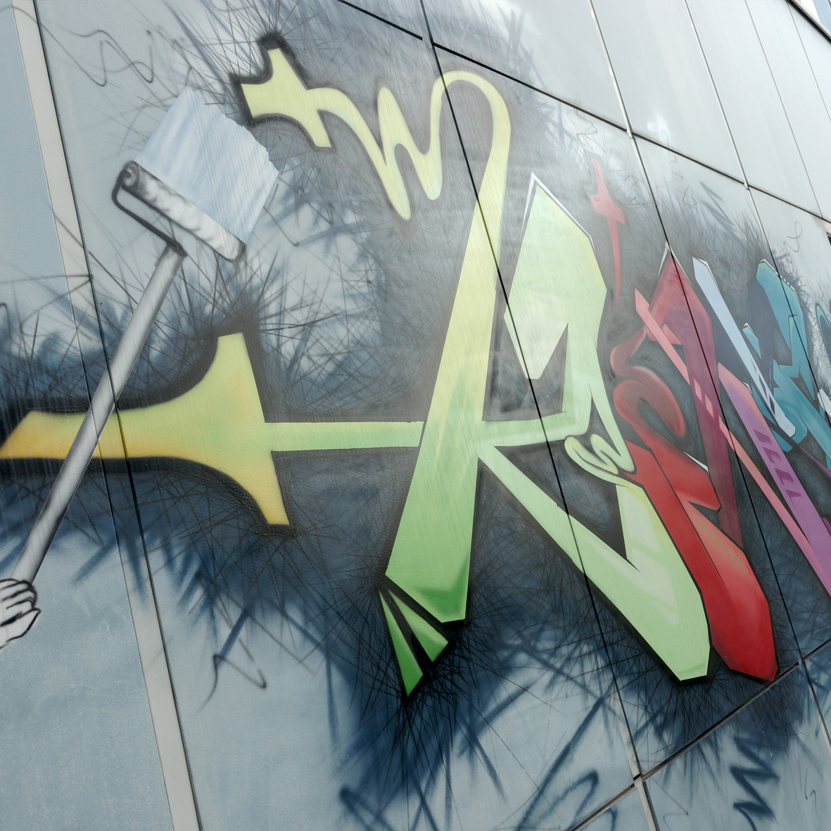 Großes Graffiti mit Pinselmotiv an einer Außenwand der Schule